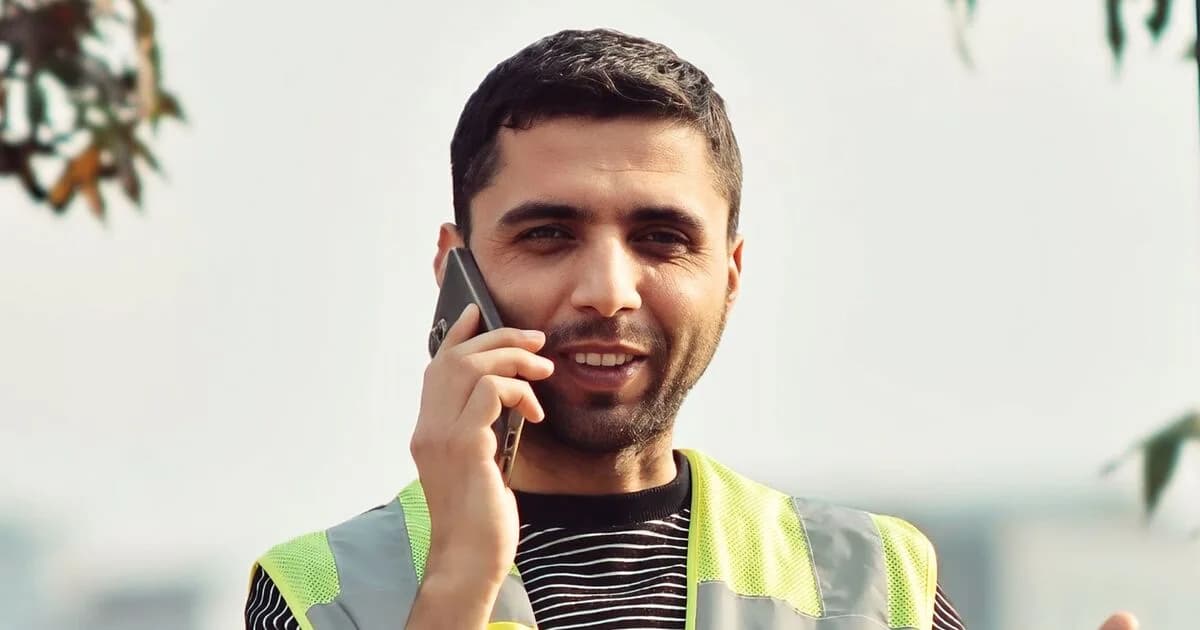 Connecticut contractor in a high-visibility vest taking a call from a customer outdoors