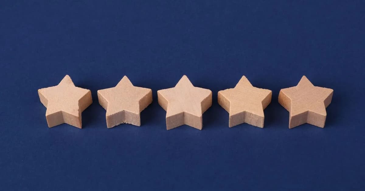Five wooden star blocks in a row, representing a five-star review rating